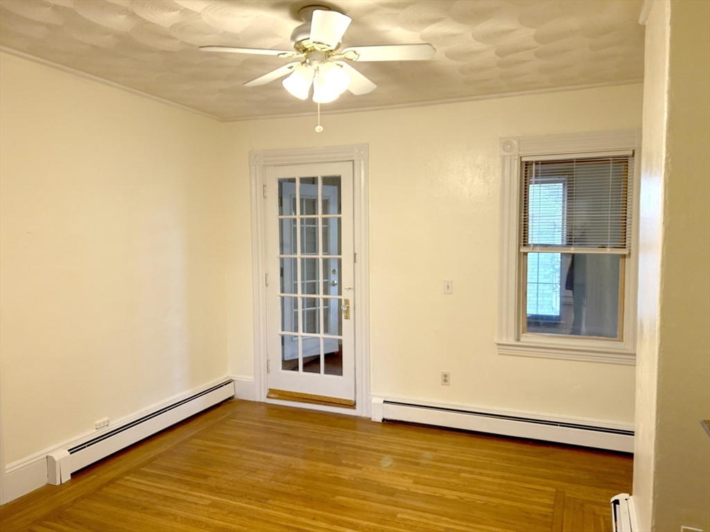 25 Baltimore Street, Unit 2/3 Lynn, MA 01902 - Photo 9 of 36 an empty room with wooden floor chandelier and windows