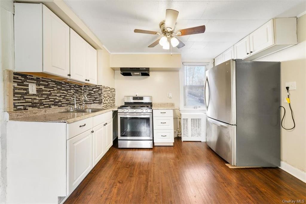 a kitchen with stainless steel appliances a stove a refrigerator and white cabinets