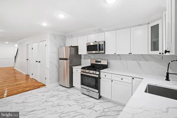 a kitchen with granite countertop a sink stove and refrigerator