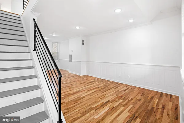 a view of a hallway with wooden floor and staircase