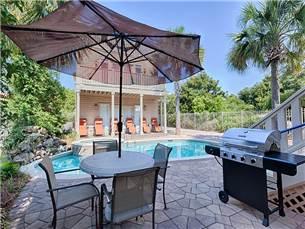 58 Sunfish Street Destin, FL 32541 - Photo 3 of 32 a patio with a table and chairs under an umbrella