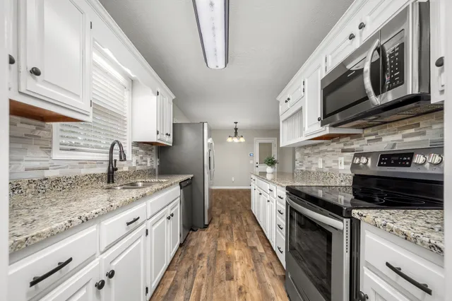 a kitchen with stainless steel appliances granite countertop a sink and a stove