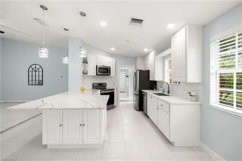 a kitchen with stainless steel appliances kitchen island granite countertop a sink and cabinets
