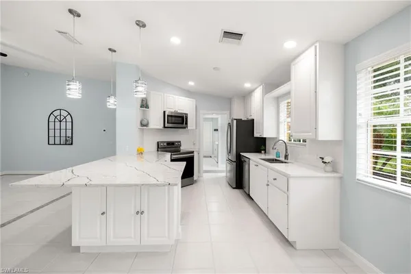 a kitchen with stainless steel appliances kitchen island granite countertop a sink and cabinets
