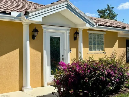 a front view of a house with a flower garden