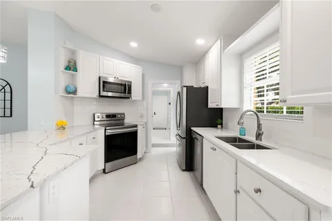 a kitchen with stainless steel appliances a stove sink microwave and refrigerator