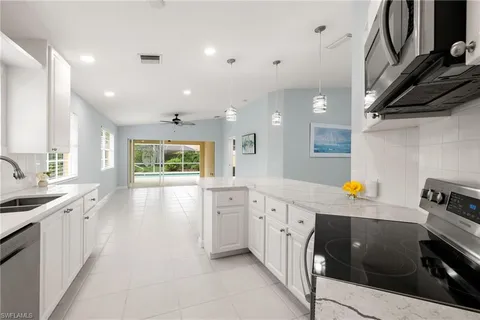 a kitchen that has a lot of cabinets in it and wooden floor