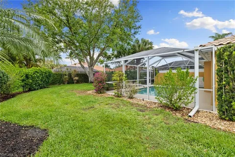 a view of a chair and table in backyard of the house