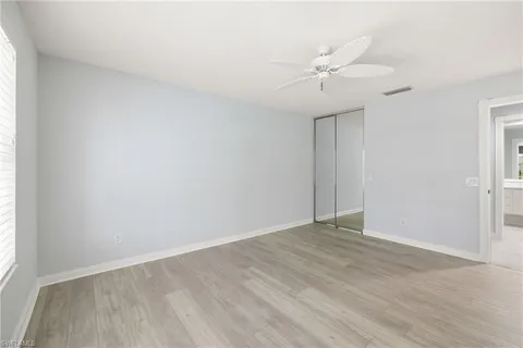an empty room with a window and a ceiling fan