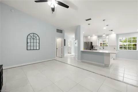 an empty room with windows and ceiling fan