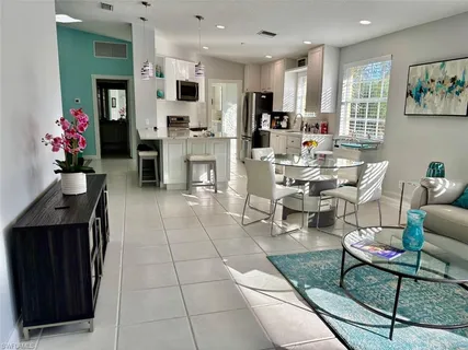 a living room with furniture a flat screen tv and kitchen view