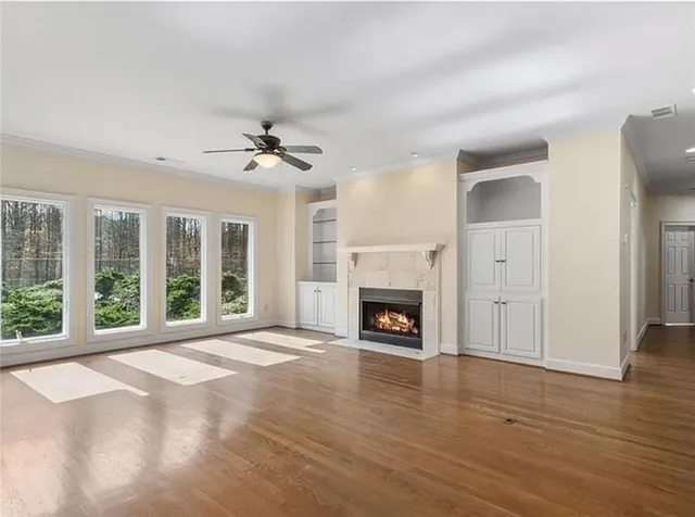 a view of an empty room with a fireplace and a window