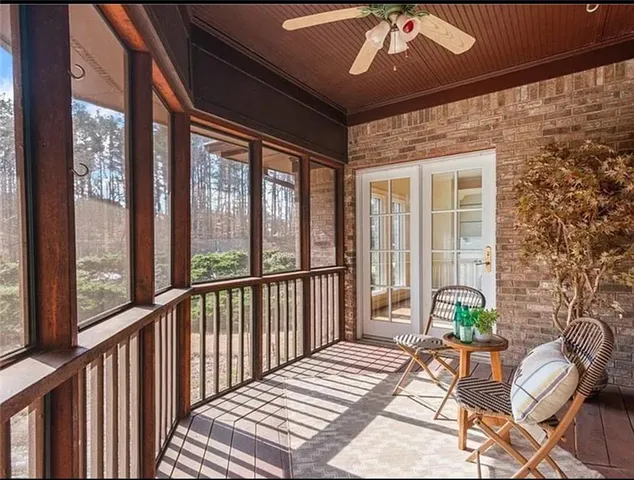 a balcony with wooden floor table and chairs