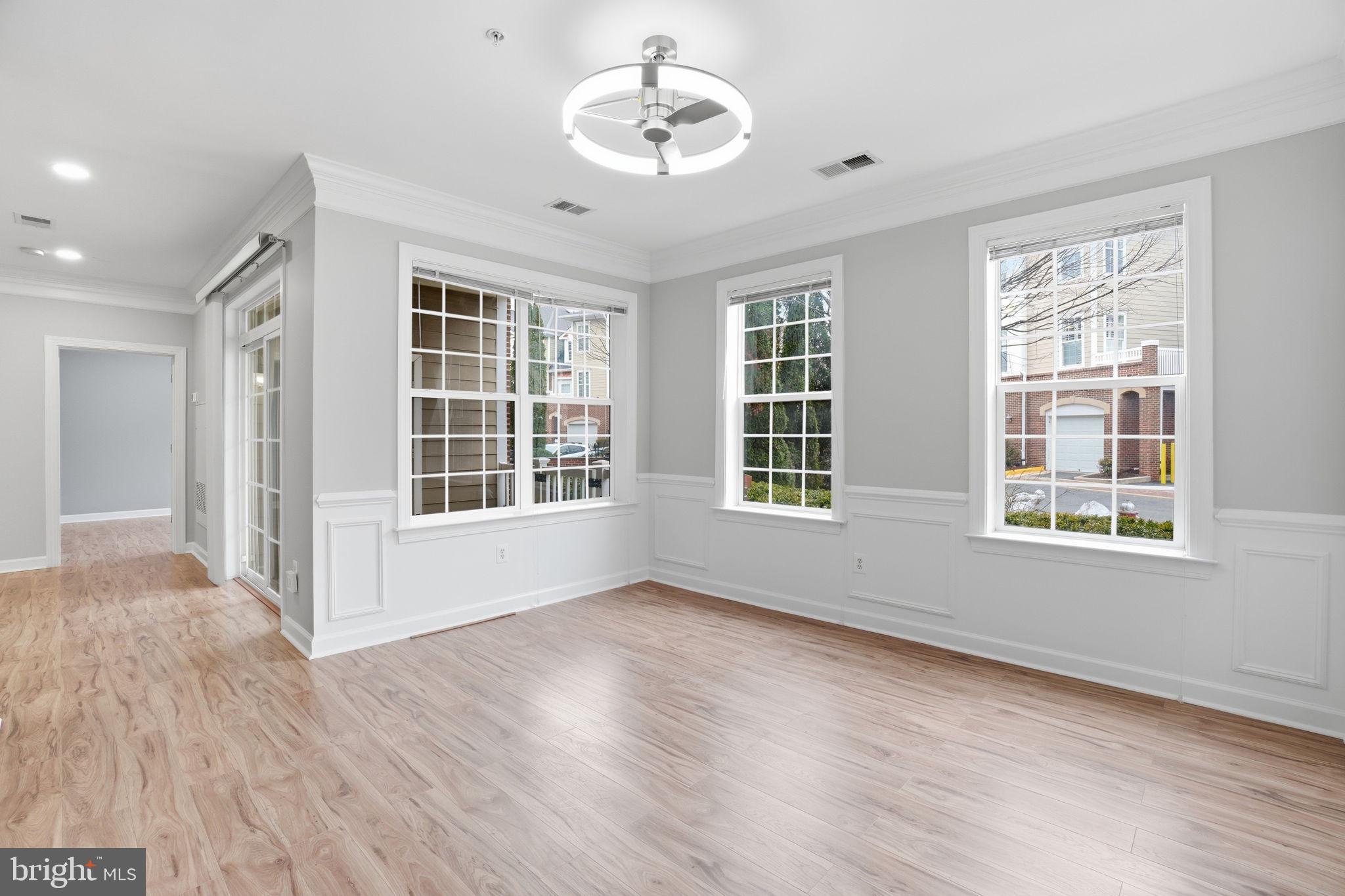 7871 Rolling Woods Court, Unit 1104 Springfield, VA 22152 - Photo 13 of 38 a view of an empty room with a window and wooden floor