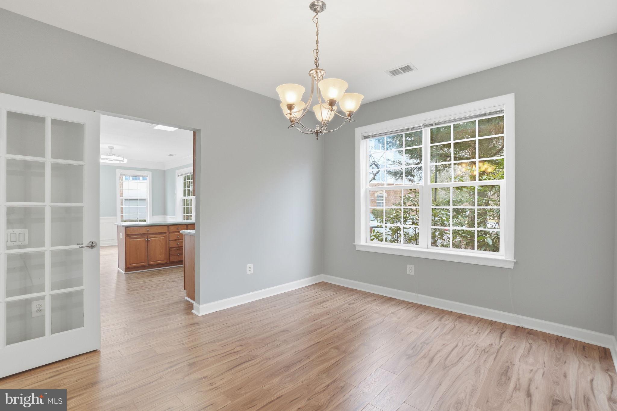 7871 Rolling Woods Court, Unit 1104 Springfield, VA 22152 - Photo 14 of 38 a view of an empty room with a window and wooden floor