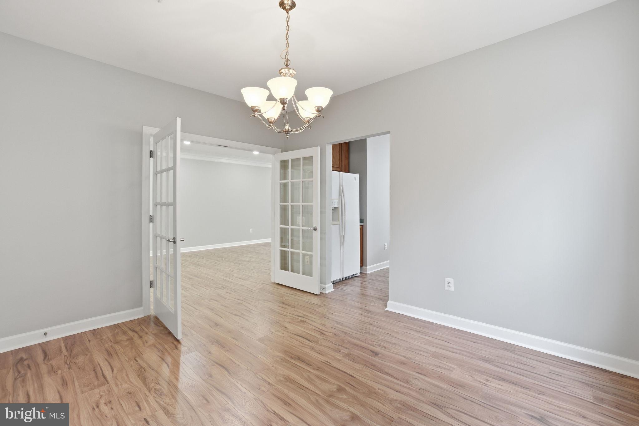 7871 Rolling Woods Court, Unit 1104 Springfield, VA 22152 - Photo 15 of 38 an empty room with wooden floor and windows