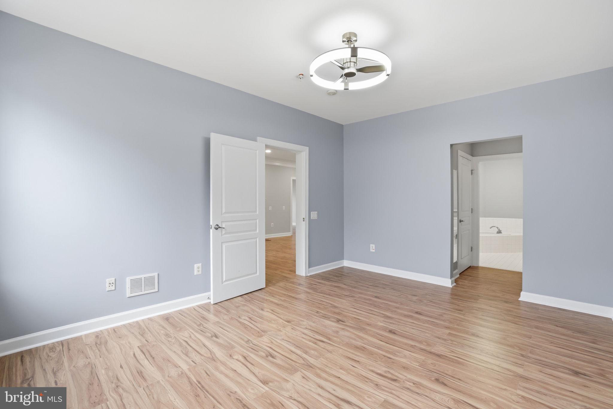 7871 Rolling Woods Court, Unit 1104 Springfield, VA 22152 - Photo 20 of 38 a view of an empty room with wooden floor