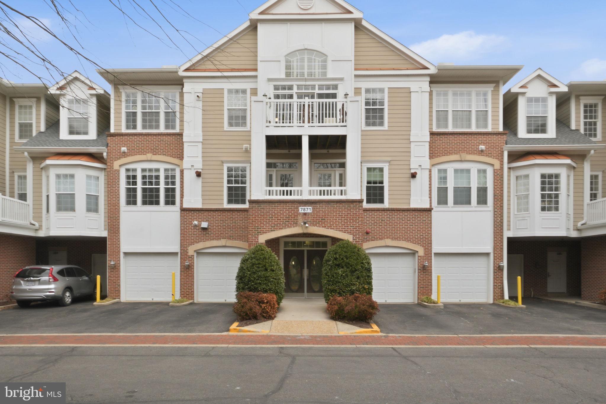 7871 Rolling Woods Court, Unit 1104 Springfield, VA 22152 - Photo 2 of 38 a front view of a residential apartment building with a yard