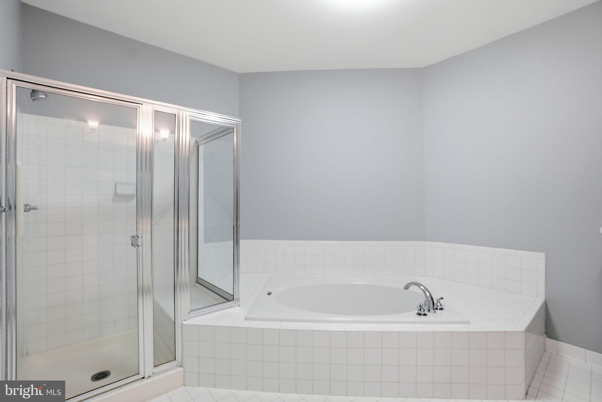 7871 Rolling Woods Court, Unit 1104 Springfield, VA 22152 - Photo 25 of 38 a bathroom with a bathtub and a shower