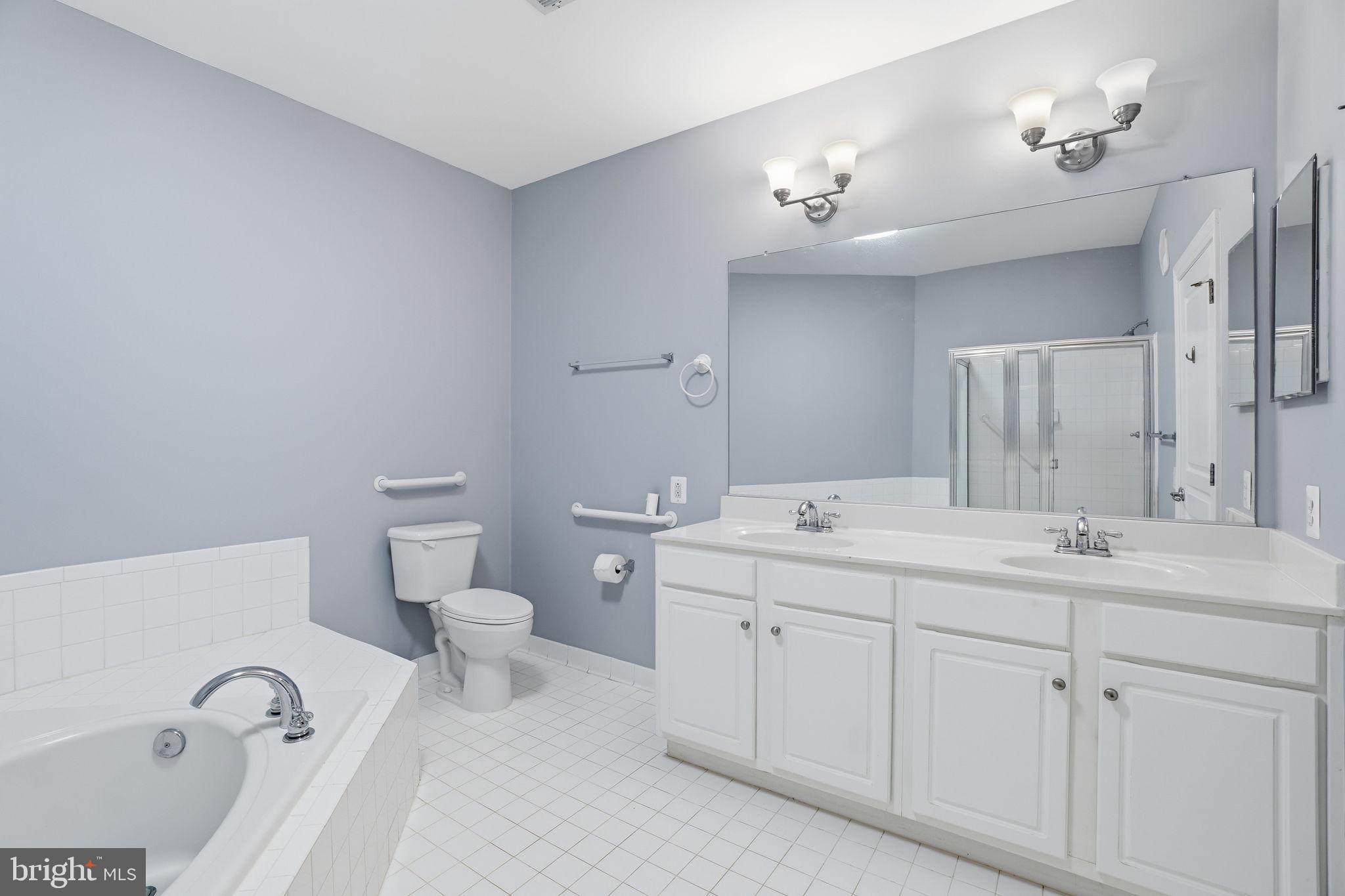 7871 Rolling Woods Court, Unit 1104 Springfield, VA 22152 - Photo 26 of 38 a bathroom with a double vanity sink a toilet and a mirror