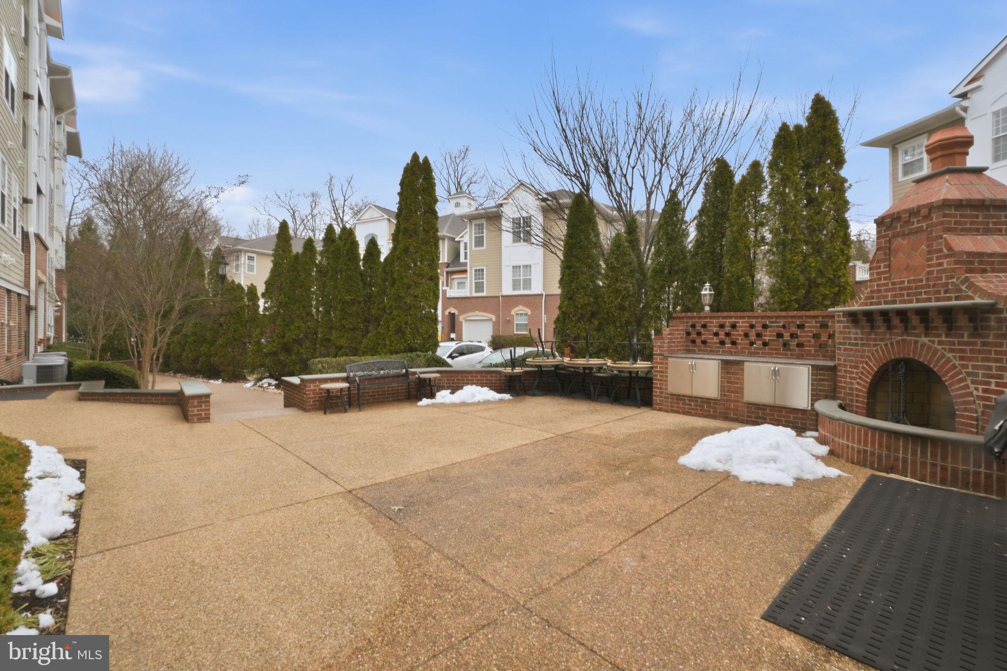 7871 Rolling Woods Court, Unit 1104 Springfield, VA 22152 - Photo 34 of 38 a view of a terrace with a bench in front of house