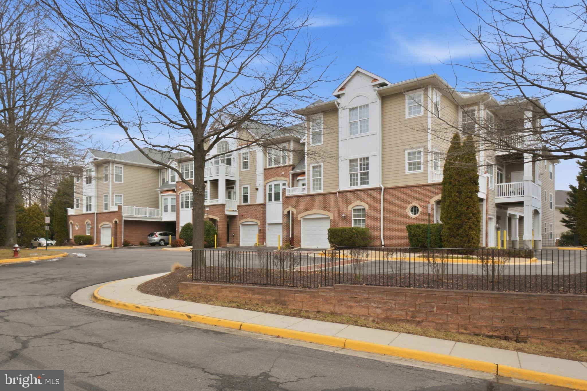 7871 Rolling Woods Court, Unit 1104 Springfield, VA 22152 - Photo 36 of 38 a view of a white house with a large tree