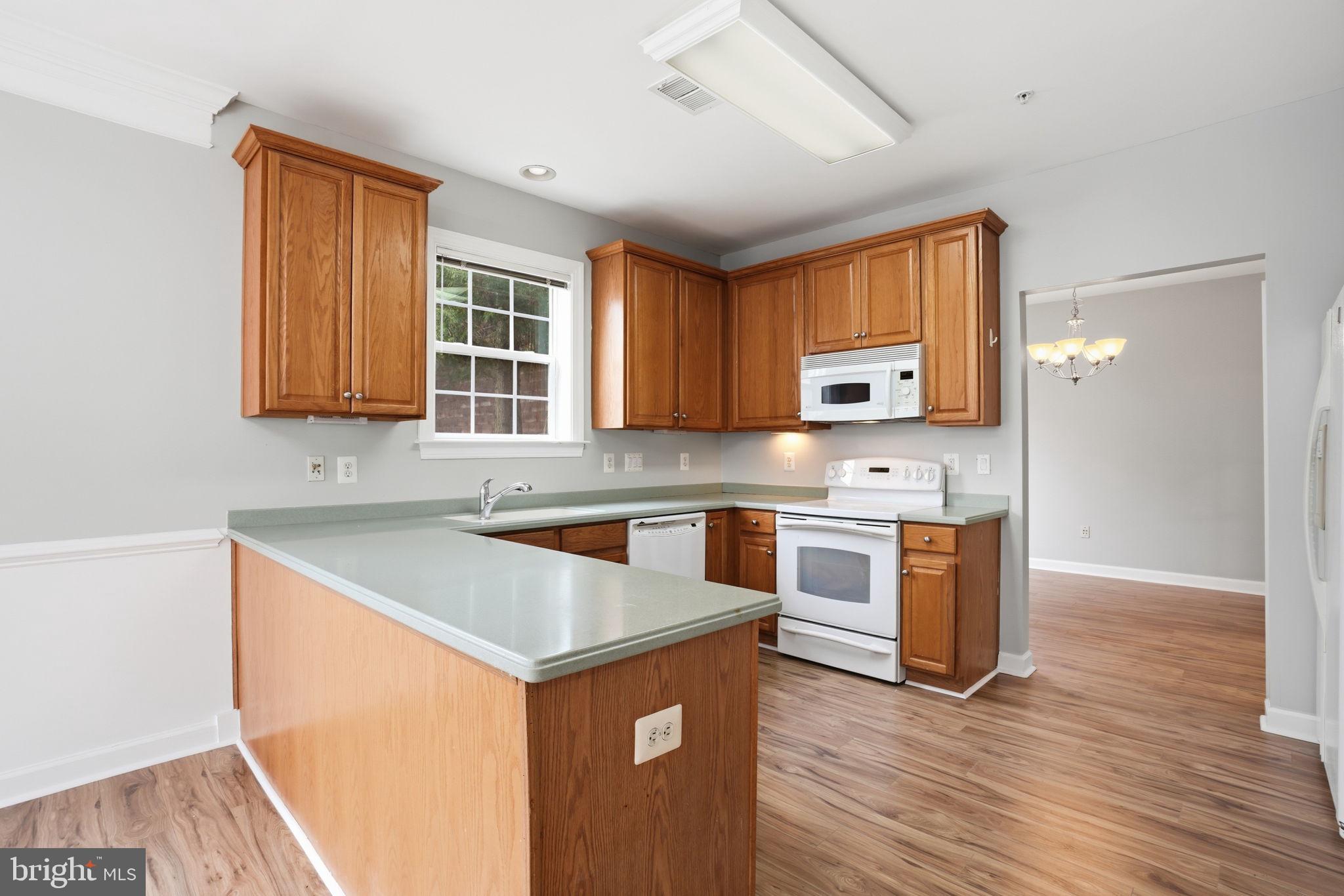 7871 Rolling Woods Court, Unit 1104 Springfield, VA 22152 - Photo 7 of 38 a kitchen with stainless steel appliances granite countertop a sink stove and microwave