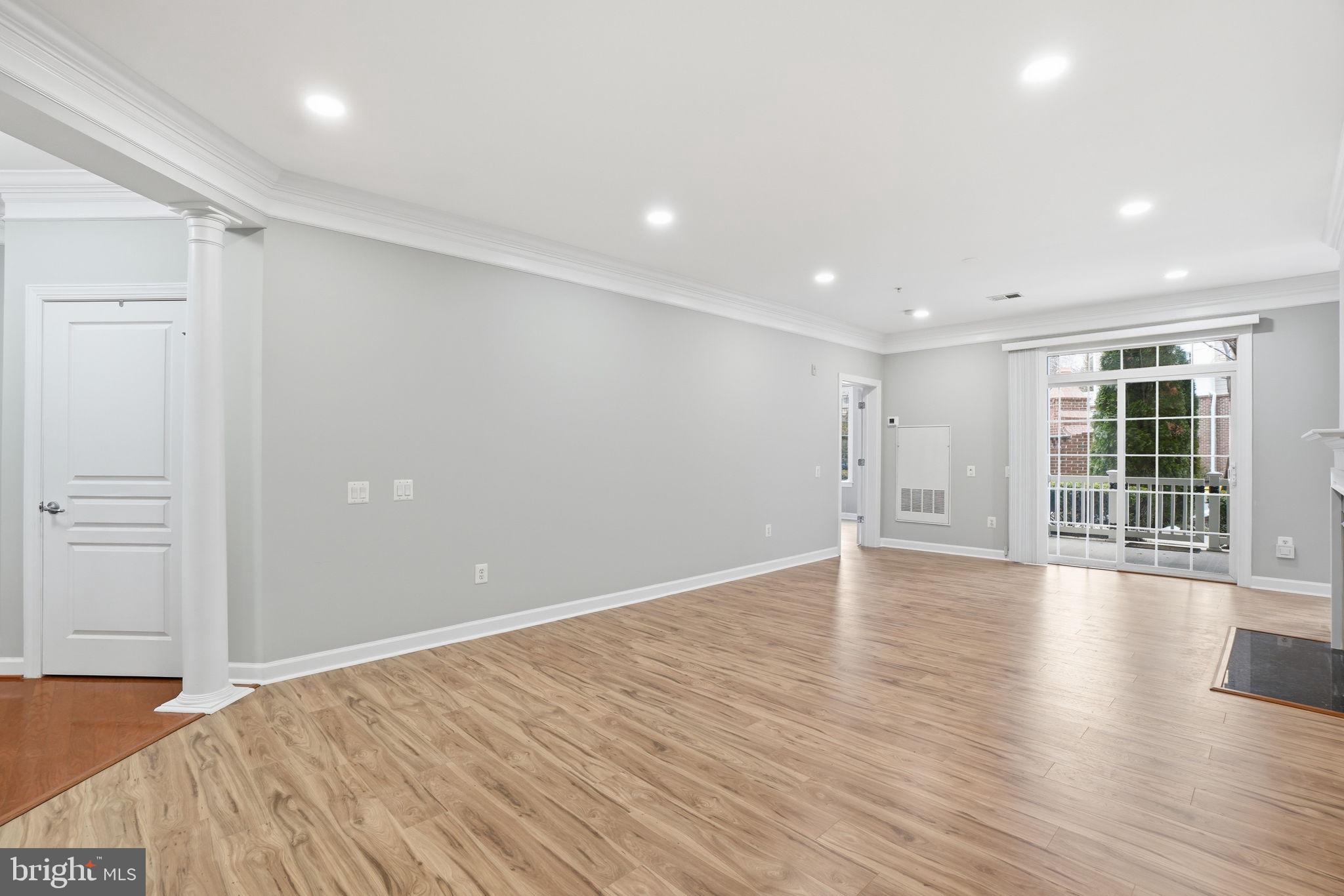 7871 Rolling Woods Court, Unit 1104 Springfield, VA 22152 - Photo 10 of 38 a view of an empty room with wooden floor and a window