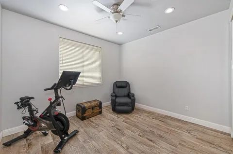 a room with gym equipment and wooden floor