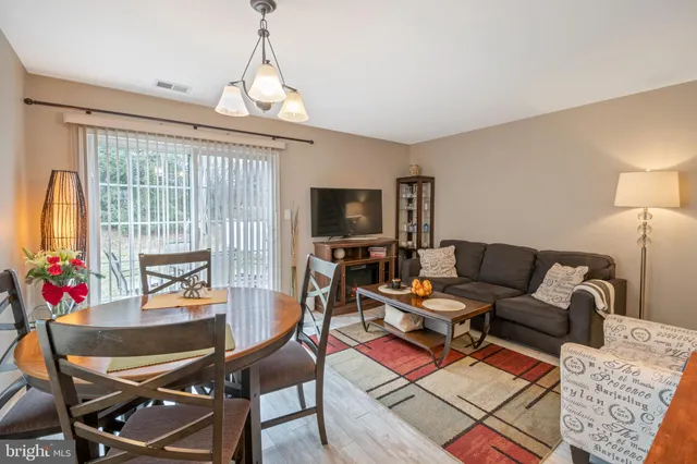 a living room with furniture a flat screen tv and a large window