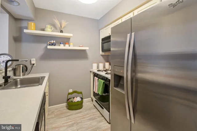 a kitchen with stainless steel appliances granite countertop a refrigerator and a sink