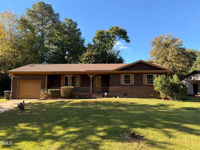 a front view of house with yard and trees