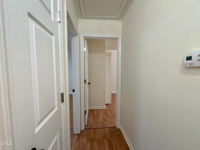 a view of a hallway with wooden floor and closet
