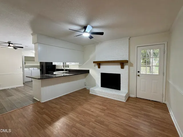 a living room with stainless steel appliances kitchen island a fireplace