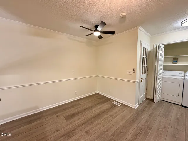 a view of a room with wooden floor and white walls