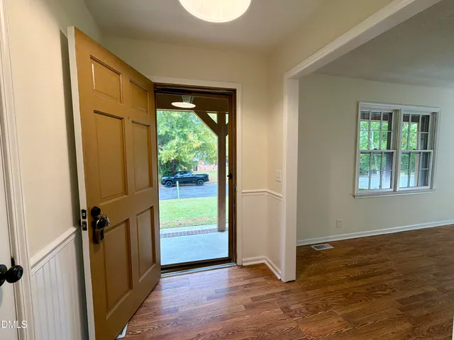 an empty room with wooden floor and a window