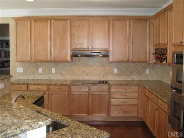 13019 Saxon Way Raleigh, NC 27613 - Photo 2 of 12 Large open kitchen w/ granite countertops, tile backsplash, SS appliances, pantry and pull up bar!