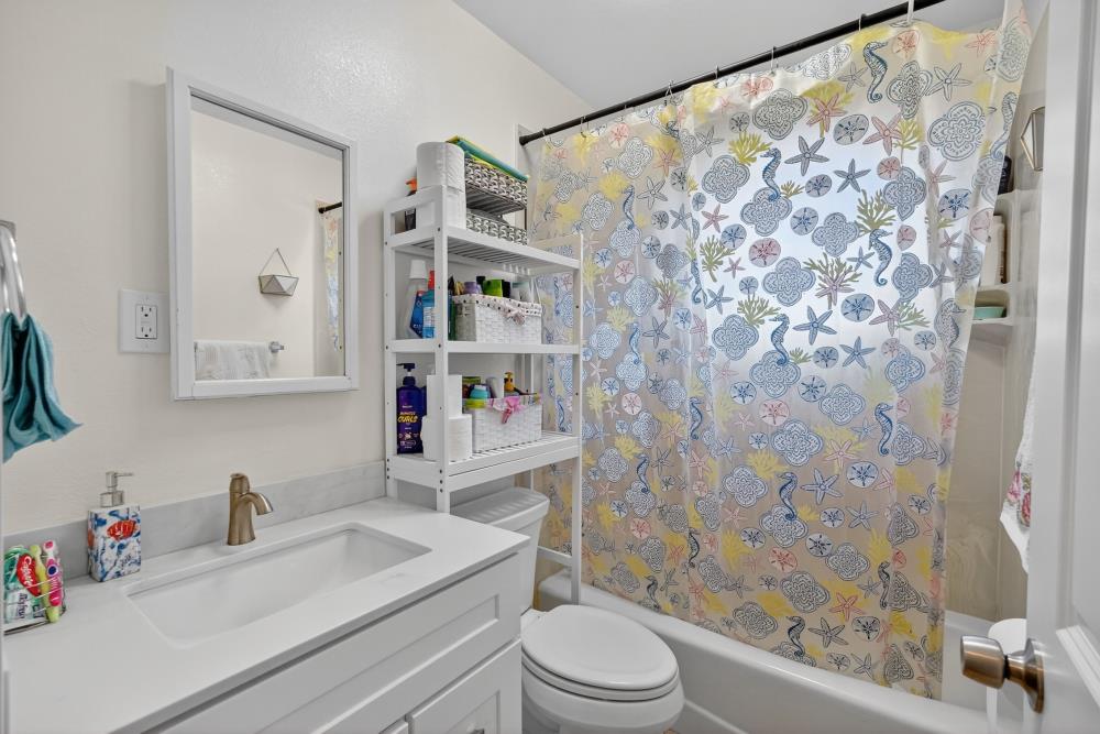 33554 7th Street Union City, CA 94587 - Photo 16 of 38 a bathroom with a sink a toilet and shower curtain
