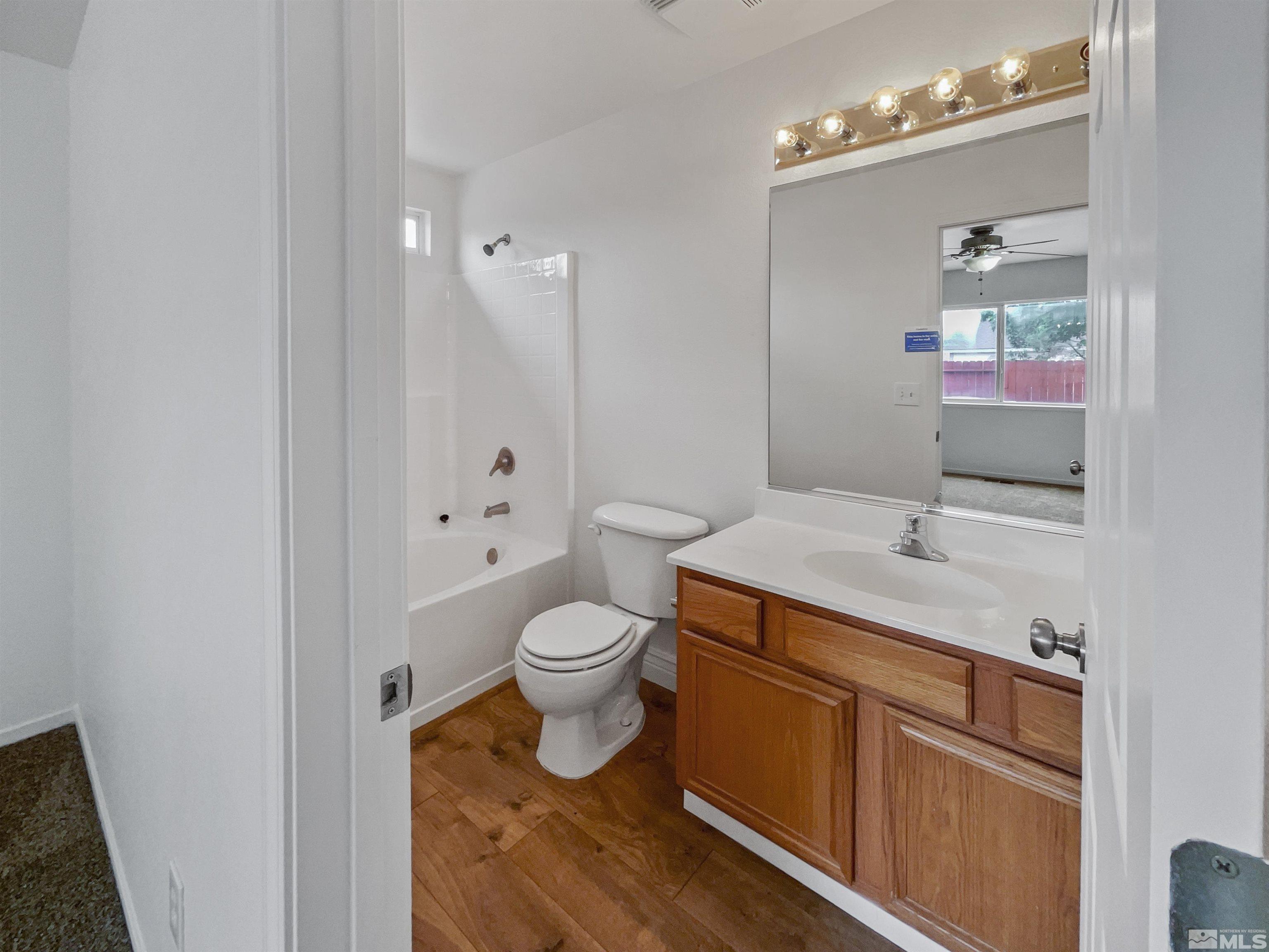 17838 Empire Court Reno, NV 89508 - Photo 11 of 20 a bathroom with a sink a toilet a mirror and shower
