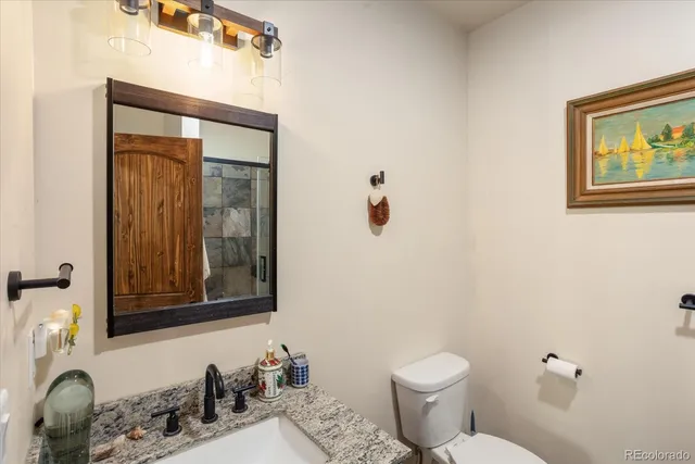 a bathroom with a toilet sink and mirror