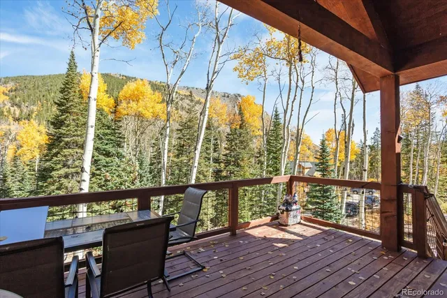 a view of a balcony with chairs and wooden floor