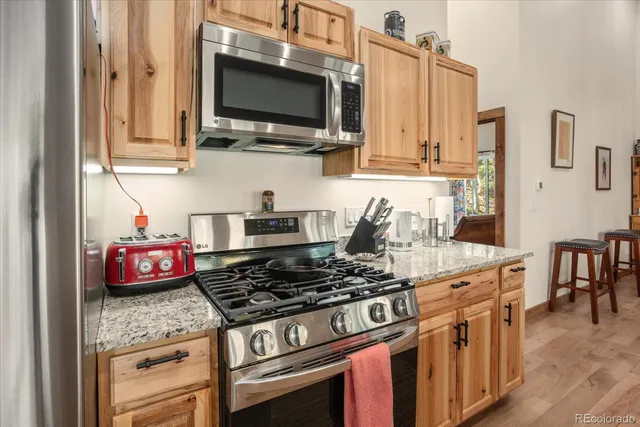 a kitchen with stainless steel appliances granite countertop a stove and a microwave