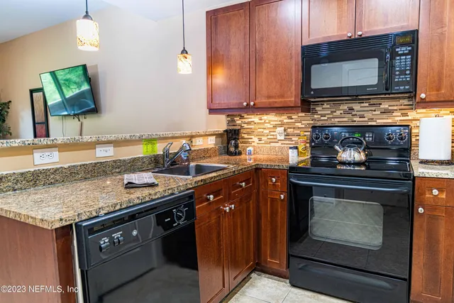a kitchen with stainless steel appliances granite countertop a stove microwave and oven