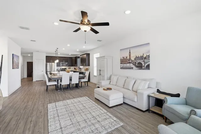 a living room with furniture and a wooden floor