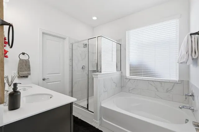 a bathroom with a tub sink and mirror