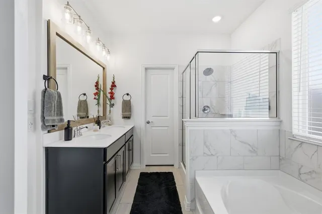 a bathroom with a bathtub a sink a vanity and a mirror