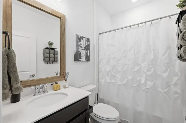 a bathroom with a sink a toilet and shower curtain