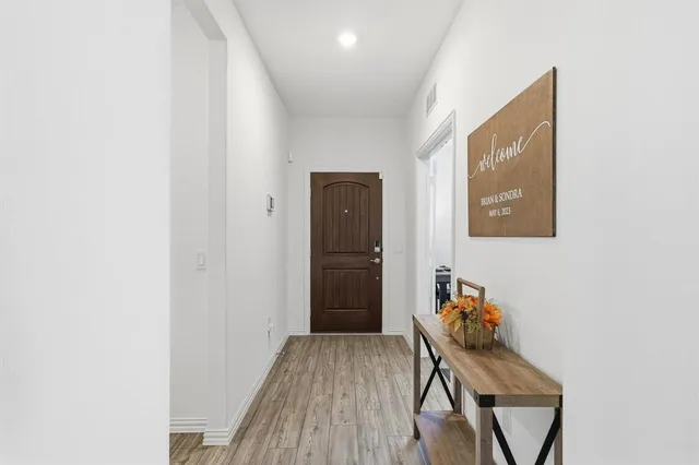 a view of a hallway with wooden floor and a workspace