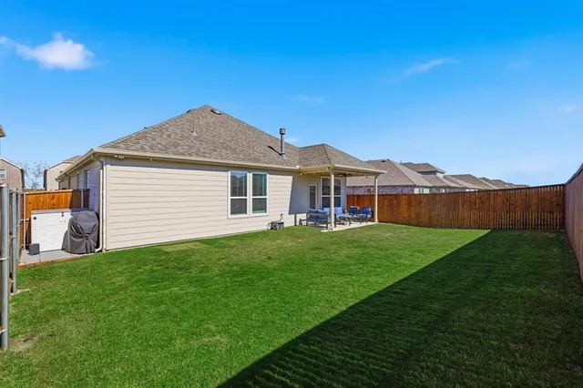 a view of a backyard with a garden and wooden fence