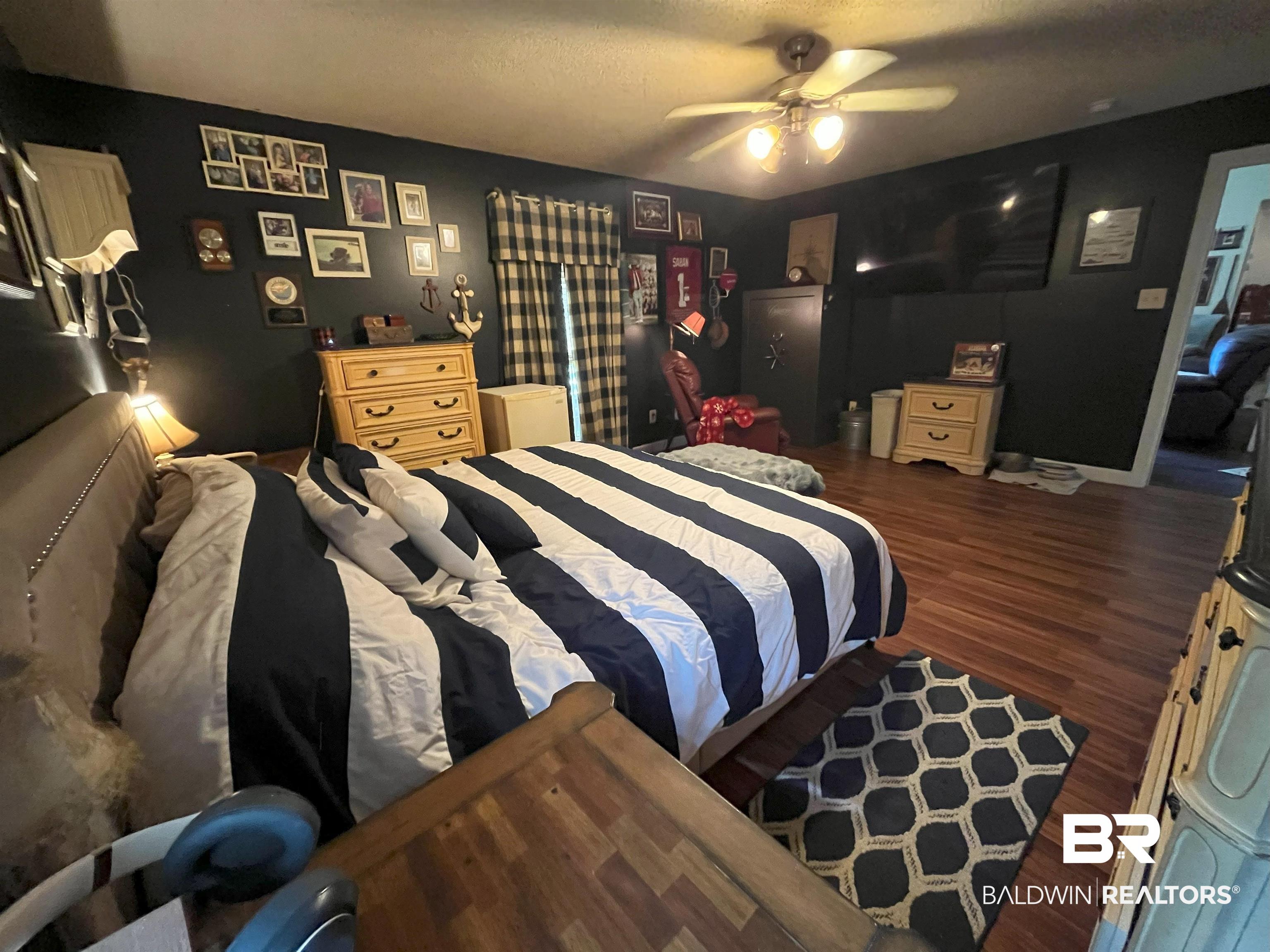 7851 Highway 98 Fairhope, AL 36532 - Photo 22 of 40 Bedroom featuring dark wood-style floors, ceiling fan, and a textured ceiling